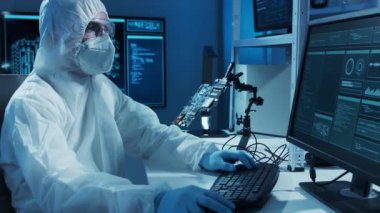 Mikro elektronik mühendisi, bilgisayar sistemleri ve mikroişlemciler üzerine modern bir bilim laboratuvarında çalışıyor. Elektronik fabrika işçisi ana kartı test ediyor ve yazılımı kodluyor..