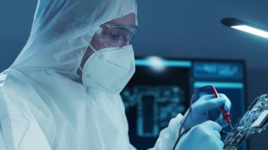 Mikro elektronik mühendisi, bilgisayar sistemleri ve mikroişlemciler üzerine modern bir bilim laboratuvarında çalışıyor. Elektronik fabrika işçisi ana kartı test ediyor ve yazılımı kodluyor..