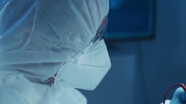 Mikro elektronik mühendisi, bilgisayar sistemleri ve mikroişlemciler üzerine modern bir bilim laboratuvarında çalışıyor. Elektronik fabrika işçisi ana kartı test ediyor ve yazılımı kodluyor..