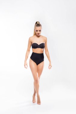 Beyaz mayo giyen genç, fit ve güzel sarışın kadın beyaz arka planda izole edilmiş. Sağlık, diyet, spor ve spor.