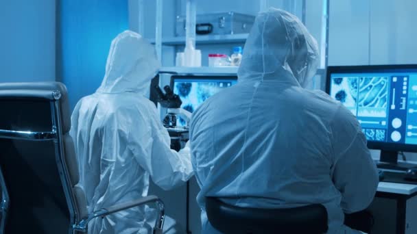 Diverse wetenschappers werken aan een vaccin in een modern wetenschappelijk onderzoekslaboratorium. Genetische ingenieur werkplek. Toekomstige technologie en wetenschapsconcept. — Stockvideo