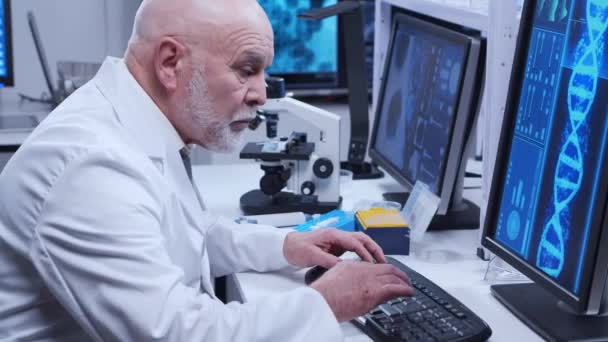 Äldre professor gör ett vetenskapligt experiment i ett modernt laboratorium. Genetiska ingenjörer på arbetsplatsen. Begreppet vetenskap, medicin och vaccinutveckling. — Stockvideo