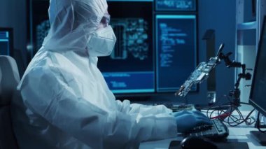 Mikro elektronik mühendisi, bilgisayar sistemleri ve mikroişlemciler üzerine modern bir bilim laboratuvarında çalışıyor. Elektronik fabrika işçisi ana kartı test ediyor ve yazılımı kodluyor..