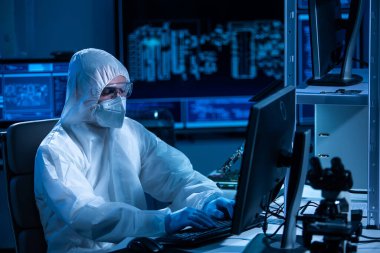 Mikro elektronik mühendisi, bilgisayar sistemleri ve mikroişlemciler üzerine modern bir bilim laboratuvarında çalışıyor. Elektronik fabrika işçisi ana kartı test ediyor ve yazılımı kodluyor..