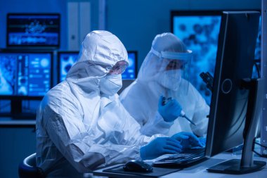 Profesyonel bilim adamları modern bir bilimsel araştırma laboratuvarında bir aşı üzerinde çalışıyorlar. Genetik mühendisliği işyeri. Gelecekteki teknoloji ve bilim konsepti.