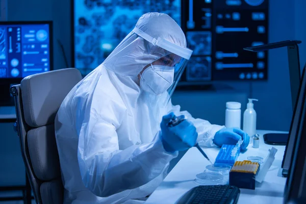 保護服の医師は科学実験を行い、現代の研究室でワクチンを開発しています。遺伝子工学の職場だ。科学と医学の概念. ロイヤリティフリーのストック画像