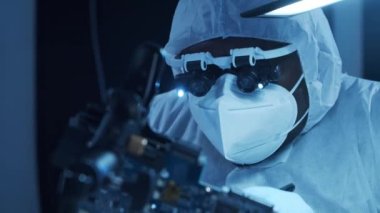 Afrikalı-Amerikalı mikro elektronik mühendisi, bilgisayar sistemleri ve mikroişlemciler üzerine modern bir bilim laboratuvarında çalışıyor. Elektronik fabrika işçisi ana kartı ve kodlamayı test ediyor..