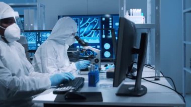 Çeşitli bilim adamları modern bir bilimsel araştırma laboratuvarında bir aşı üzerinde çalışıyorlar. Genetik mühendisliği işyeri. Gelecekteki teknoloji ve bilim konsepti.