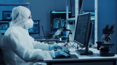 Mikro elektronik mühendisi, bilgisayar sistemleri ve mikroişlemciler üzerine modern bir bilim laboratuvarında çalışıyor. Elektronik fabrika işçisi ana kartı test ediyor ve yazılımı kodluyor..