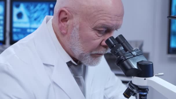 Der ältere Professor macht ein naturwissenschaftliches Experiment in einem modernen Labor. Gentechniker am Arbeitsplatz. Das Konzept von Wissenschaft, Medizin und Impfstoffentwicklung. — Stockvideo