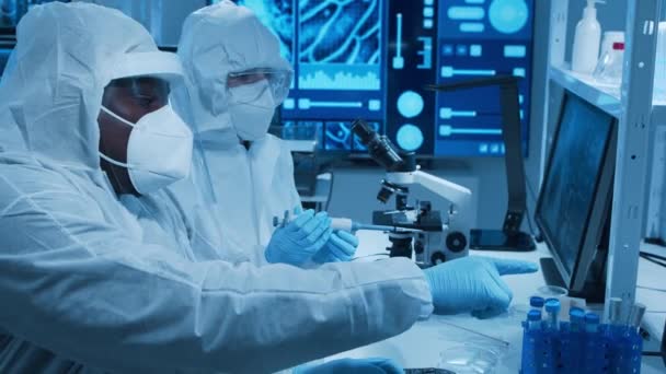 Olika forskarlag arbetar med ett vaccin i ett modernt vetenskapligt forskningslaboratorium. Genetisk ingenjör på arbetsplatsen. Framtida teknik och vetenskapskoncept. — Stockvideo