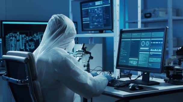 Microelectronics engineer works in a modern scientific laboratory on computing systems and microprocessors. Electronic factory worker is testing the motherboard and coding the firmware. — Stock Video