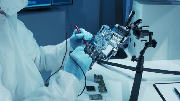 Mikroelektronikingenjör arbetar i ett modernt vetenskapligt laboratorium med datorsystem och mikroprocessorer. Elektronisk fabriksarbetare testar moderkortet och kodar den inbyggda programvaran. — Stockvideo