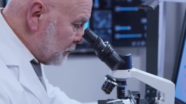 Yaşlı profesör modern bir laboratuvarda bilim deneyi yapıyor. Genetik mühendisliği işyeri. Bilim, ilaç ve aşı geliştirme kavramı.