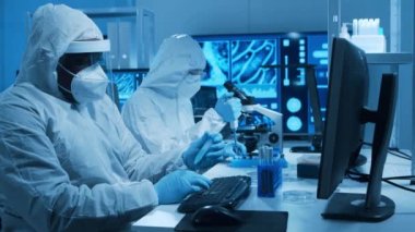 Çeşitli bilim adamları modern bir bilimsel araştırma laboratuvarında bir aşı üzerinde çalışıyorlar. Genetik mühendisliği işyeri. Gelecekteki teknoloji ve bilim konsepti.