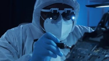 Afrikalı-Amerikalı mikro elektronik mühendisi, bilgisayar sistemleri ve mikroişlemciler üzerine modern bir bilim laboratuvarında çalışıyor. Elektronik fabrika işçisi ana kartı ve kodlamayı test ediyor..