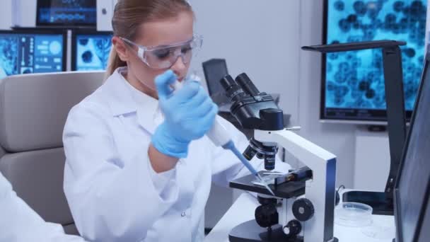 Profesor de edad avanzada y joven asistente de laboratorio están haciendo experimentos científicos en un laboratorio moderno. Laboratorio de ingenieros genéticos. El concepto de ciencia, medicina y desarrollo de vacunas. — Vídeos de Stock