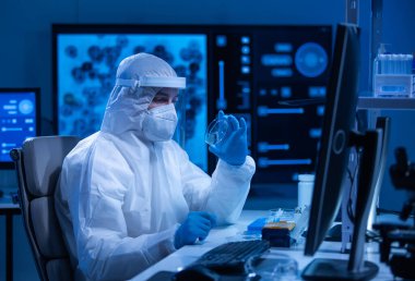 Koruyucu kıyafetli doktor modern bir laboratuvarda bilimsel deneyler yapıyor ve aşı geliştiriyor. Genetik mühendisliği işyeri. Bilim ve tıp kavramı.