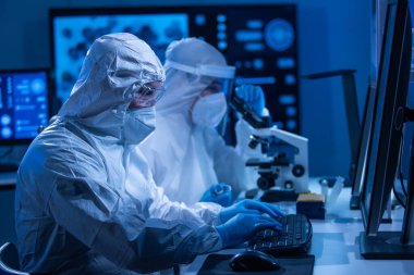 Profesyonel bilim adamları modern bir bilimsel araştırma laboratuvarında bir aşı üzerinde çalışıyorlar. Genetik mühendisliği işyeri. Gelecekteki teknoloji ve bilim konsepti.