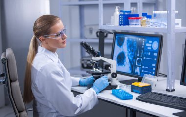 Profesyonel kadın bilim adamı bir bilimsel araştırma laboratuvarında aşı üzerinde çalışıyor. Genetik mühendisliği işyeri. Teknoloji ve bilim konsepti.