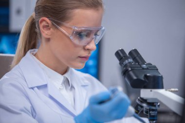 Profesyonel kadın bilim adamı bir bilimsel araştırma laboratuvarında aşı üzerinde çalışıyor. Genetik mühendisliği işyeri. Teknoloji ve bilim konsepti.