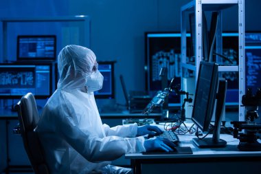 Mikro elektronik mühendisi, bilgisayar sistemleri ve mikroişlemciler üzerine modern bir bilim laboratuvarında çalışıyor. Elektronik fabrika işçisi ana kartı test ediyor ve yazılımı kodluyor..