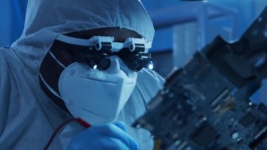 Afrikalı-Amerikalı mikro elektronik mühendisi, bilgisayar sistemleri ve mikroişlemciler üzerine modern bir bilim laboratuvarında çalışıyor. Elektronik fabrika işçisi ana kartı ve kodlamayı test ediyor..