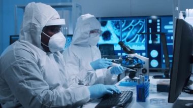 Çeşitli bilim adamları modern bir bilimsel araştırma laboratuvarında bir aşı üzerinde çalışıyorlar. Genetik mühendisliği işyeri. Gelecekteki teknoloji ve bilim konsepti.