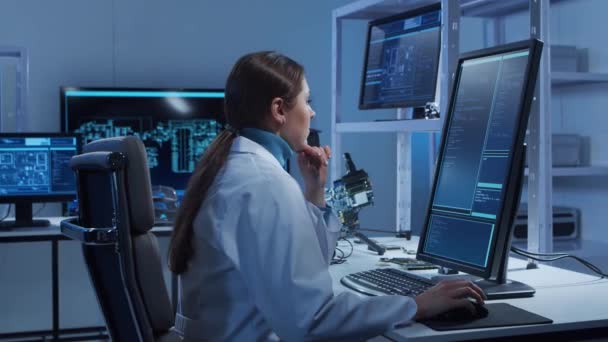 La ingeniera de microelectrónica femenina trabaja en un moderno laboratorio científico sobre sistemas informáticos y microprocesadores. El trabajador electrónico de la fábrica está probando la placa base y codificando el firmware. — Vídeos de Stock