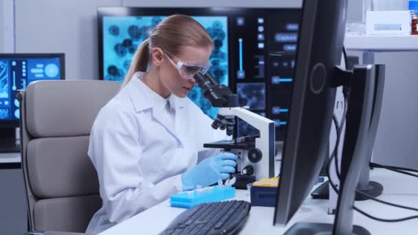 プロの女性科学者は現代の科学研究所でワクチンを研究している。遺伝子工学の職場だ。未来技術と科学の概念. — ストック動画