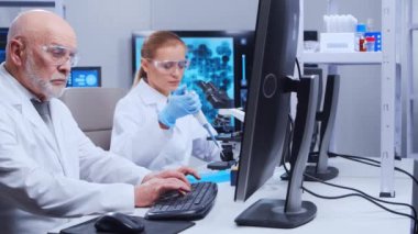 Yaşlı profesör ve genç laboratuvar asistanı modern bir laboratuvarda bilimsel deney yapıyorlar. Genetik mühendisliği işyeri. Bilim, ilaç ve aşı geliştirme kavramı.