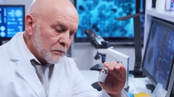 Il professore anziano sta facendo un esperimento scientifico in un laboratorio moderno. Ingegneri genetici sul lavoro. Il concetto di scienza, medicina e sviluppo del vaccino. — Video Stock