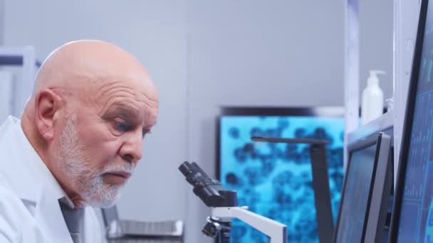 Äldre professor gör ett vetenskapligt experiment i ett modernt laboratorium. Genetiska ingenjörer på arbetsplatsen. Begreppet vetenskap, medicin och vaccinutveckling. — Stockvideo