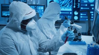 Çeşitli bilim adamları modern bir bilimsel araştırma laboratuvarında bir aşı üzerinde çalışıyorlar. Genetik mühendisliği işyeri. Gelecekteki teknoloji ve bilim konsepti.