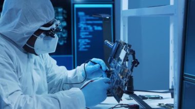 Afrikalı-Amerikalı mikro elektronik mühendisi, bilgisayar sistemleri ve mikroişlemciler üzerine modern bir bilim laboratuvarında çalışıyor. Elektronik fabrika işçisi ana kartı ve kodlamayı test ediyor..