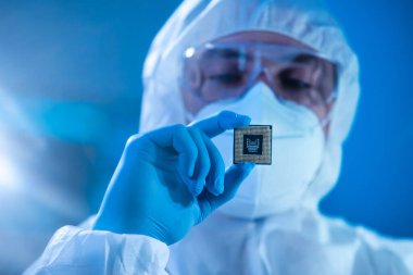 Mikro elektronik mühendisi, bilgisayar sistemleri ve mikroişlemciler üzerine modern bir bilim laboratuvarında çalışıyor. Elektronik fabrika işçisi ana kartı test ediyor ve yazılımı kodluyor..