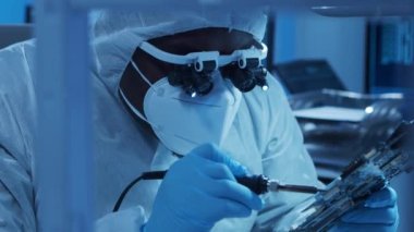 Afrikalı-Amerikalı mikro elektronik mühendisi, bilgisayar sistemleri ve mikroişlemciler üzerine modern bir bilim laboratuvarında çalışıyor. Elektronik fabrika işçisi ana kartı ve kodlamayı test ediyor..