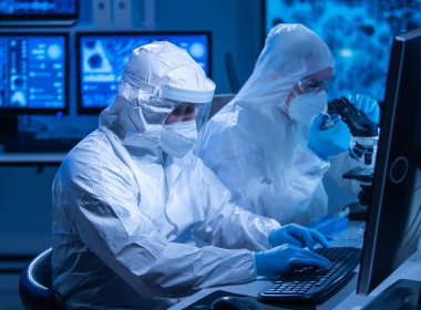 Profesyonel bilim adamları modern bir bilimsel araştırma laboratuvarında bir aşı üzerinde çalışıyorlar. Genetik mühendisliği işyeri. Gelecekteki teknoloji ve bilim konsepti.