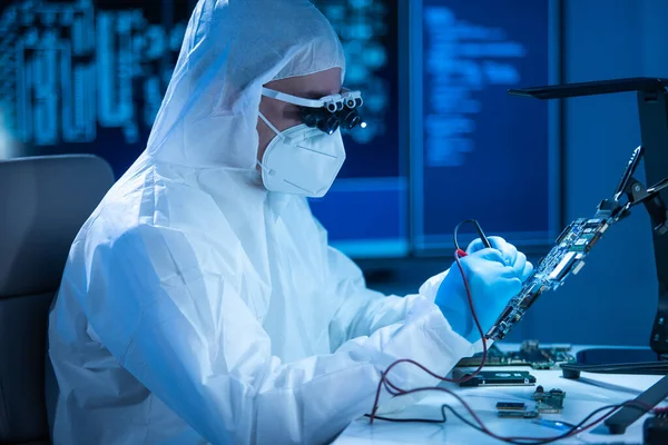 Mikro elektronik mühendisi, bilgisayar sistemleri ve mikroişlemciler üzerine modern bir bilim laboratuvarında çalışıyor. Elektronik fabrika işçisi ana kartı test ediyor ve yazılımı kodluyor..