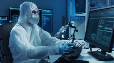 Mikro elektronik mühendisi, bilgisayar sistemleri ve mikroişlemciler üzerine modern bir bilim laboratuvarında çalışıyor. Elektronik fabrika işçisi ana kartı test ediyor ve yazılımı kodluyor..