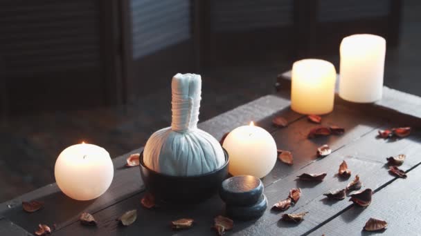 Fundo de spa. Velas, pedras de massagem e bolas de ervas. Massagem, terapia oriental, bem-estar e meditação. — Vídeo de Stock