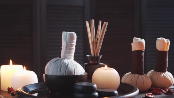Spa background. Candles, massaging stones and herbal balls. Massage, oriental therapy, wellbeing and meditation. — Stock Video