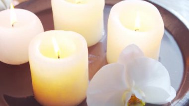 Spa arka planı. Havlu, mumlar, çiçekler, masaj taşları ve bitkisel toplar. Masaj, oryantal terapi, refah ve meditasyon.