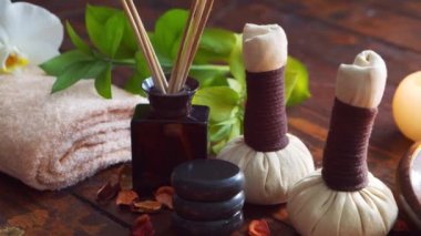 Spa arka planı. Havlu, mumlar, çiçekler, masaj taşları ve bitkisel toplar. Masaj, oryantal terapi, refah ve meditasyon.