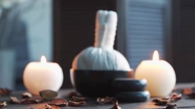 Spa arka planı. Mumlar, masaj taşları ve bitkisel toplar. Masaj, oryantal terapi, refah ve meditasyon.