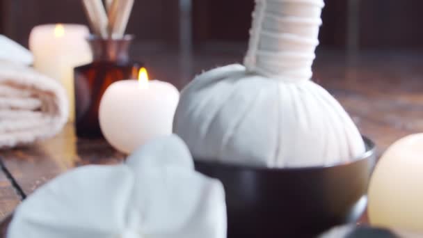 Спа фон. Полотенце, свечи, цветы, массажные камни и травяные шарики. Массаж, восточная терапия, благополучие и медитация. — стоковое видео