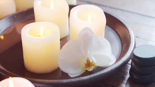 Fondo del spa. Toalla, velas, flores, piedras masajeadoras y bolas de hierbas. Masaje, terapia oriental, bienestar y meditación. — Vídeo de stock
