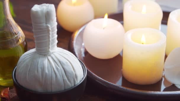 Spa bakgrund. Handduk, ljus, blommor, massagestenar och örtbollar. Massage, orientalisk terapi, välbefinnande och meditation. — Stockvideo