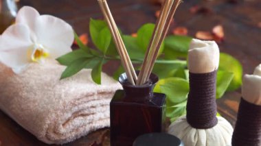 Spa arka planı. Havlu, mumlar, çiçekler, masaj taşları ve bitkisel toplar. Masaj, oryantal terapi, refah ve meditasyon.