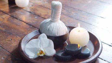 Spa arka planı. Havlu, mumlar, çiçekler, masaj taşları ve bitkisel toplar. Masaj, oryantal terapi, refah ve meditasyon.